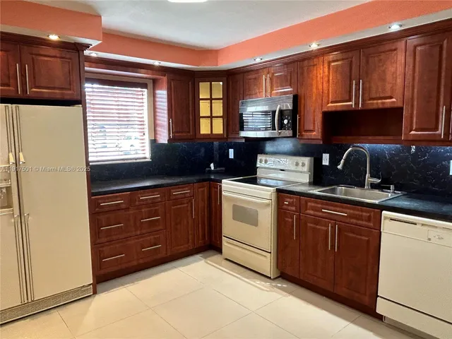 a kitchen with a sink a stove and cabinets