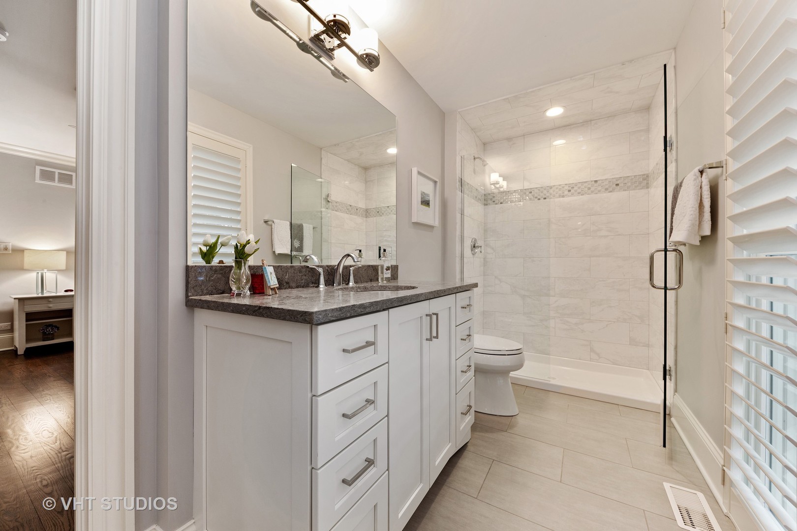 2801 Meyers Road Oak Brook, IL 60523 - Photo 25 of 48 a bathroom with a granite countertop sink a toilet a mirror and shower