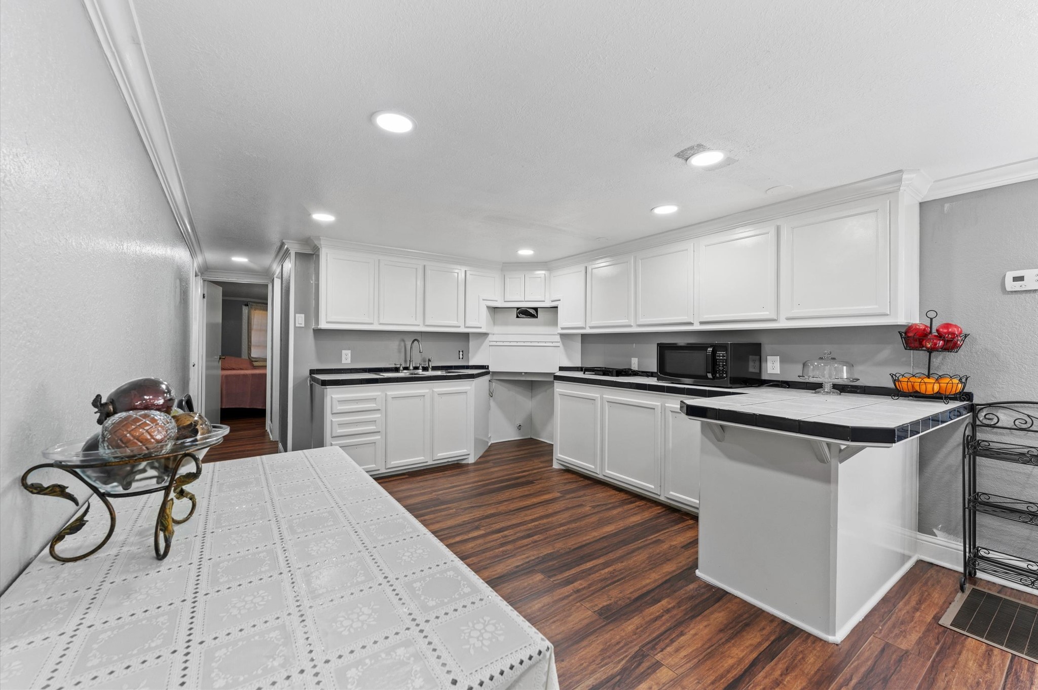 2504 Oak Ridge Road Willis, TX 77378 - Photo 8 of 10 a kitchen with white cabinets appliances and wooden floor
