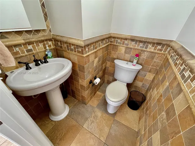 a bathroom with a sink mirror vanity and toilet