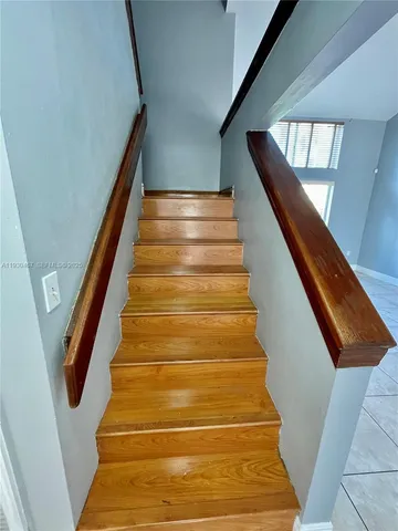 a view of an empty room with closet and wooden floor