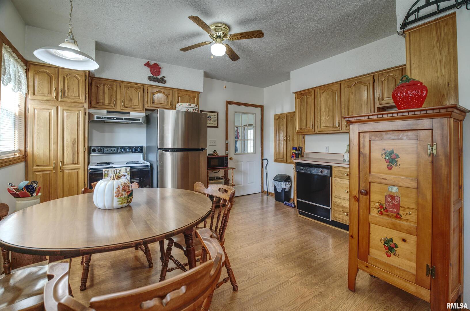 500 4th Avenue North Clinton, IA 52732 - Photo 7 of 18 a kitchen with stainless steel appliances a dining table chairs and refrigerator