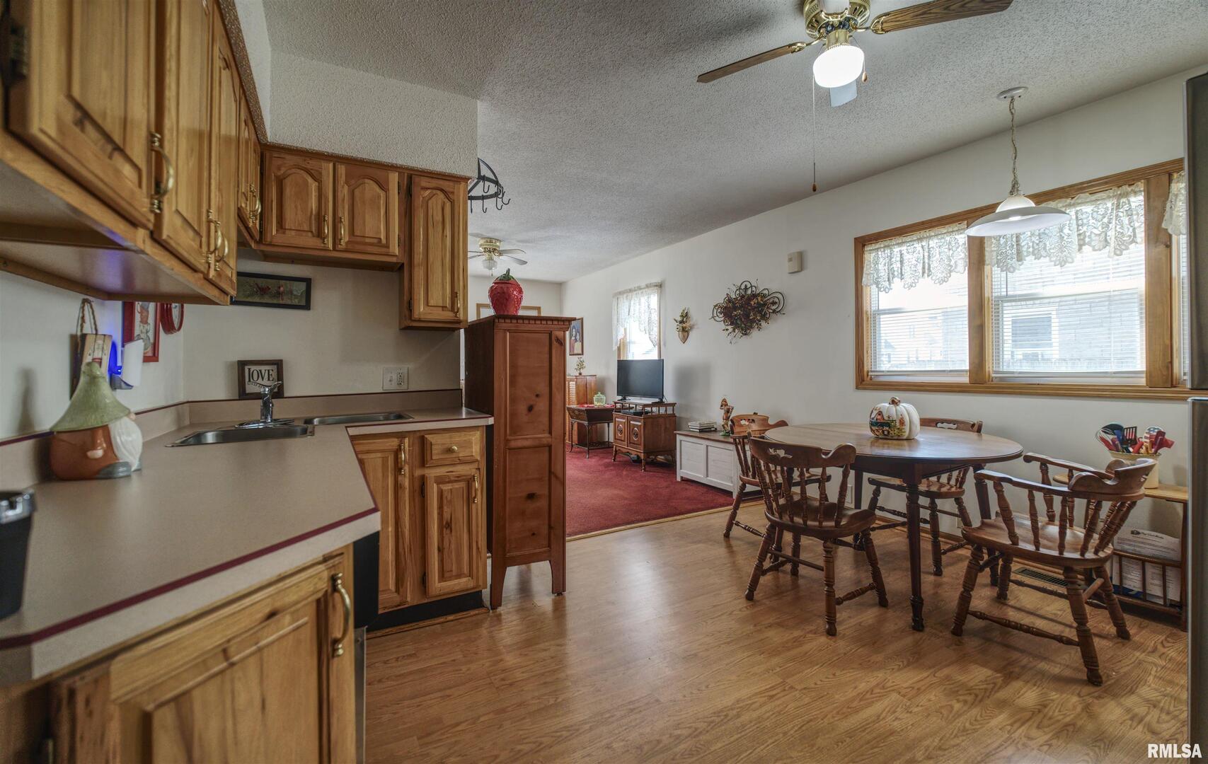 500 4th Avenue North Clinton, IA 52732 - Photo 8 of 18 a kitchen with stainless steel appliances granite countertop a refrigerator a sink dishwasher a dining table and chairs with wooden floor