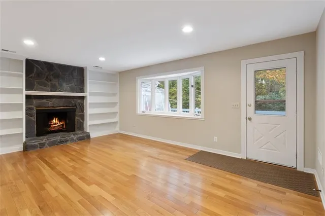 a view of empty room with wooden floor and windows