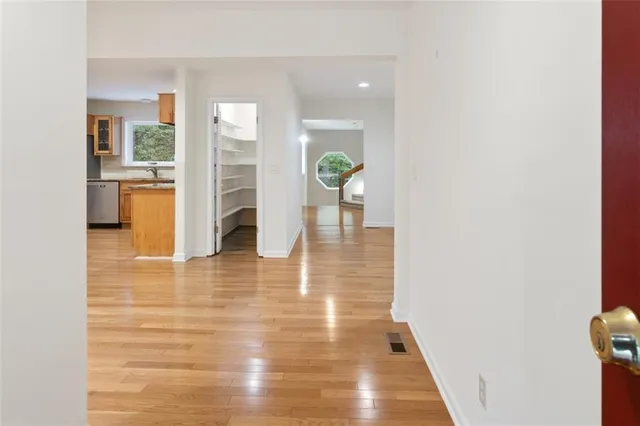an empty room with wooden floor and windows