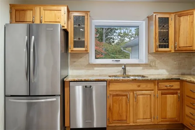 a bathroom with a granite countertop sink a toilet and shower