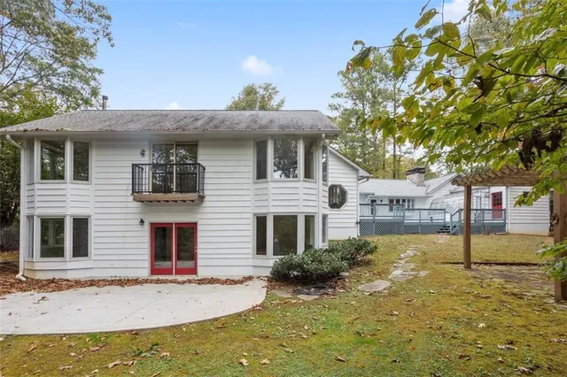 a view of a white house with a small yard and plants