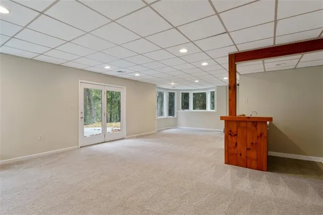 a view of a white house with large windows and a small yard