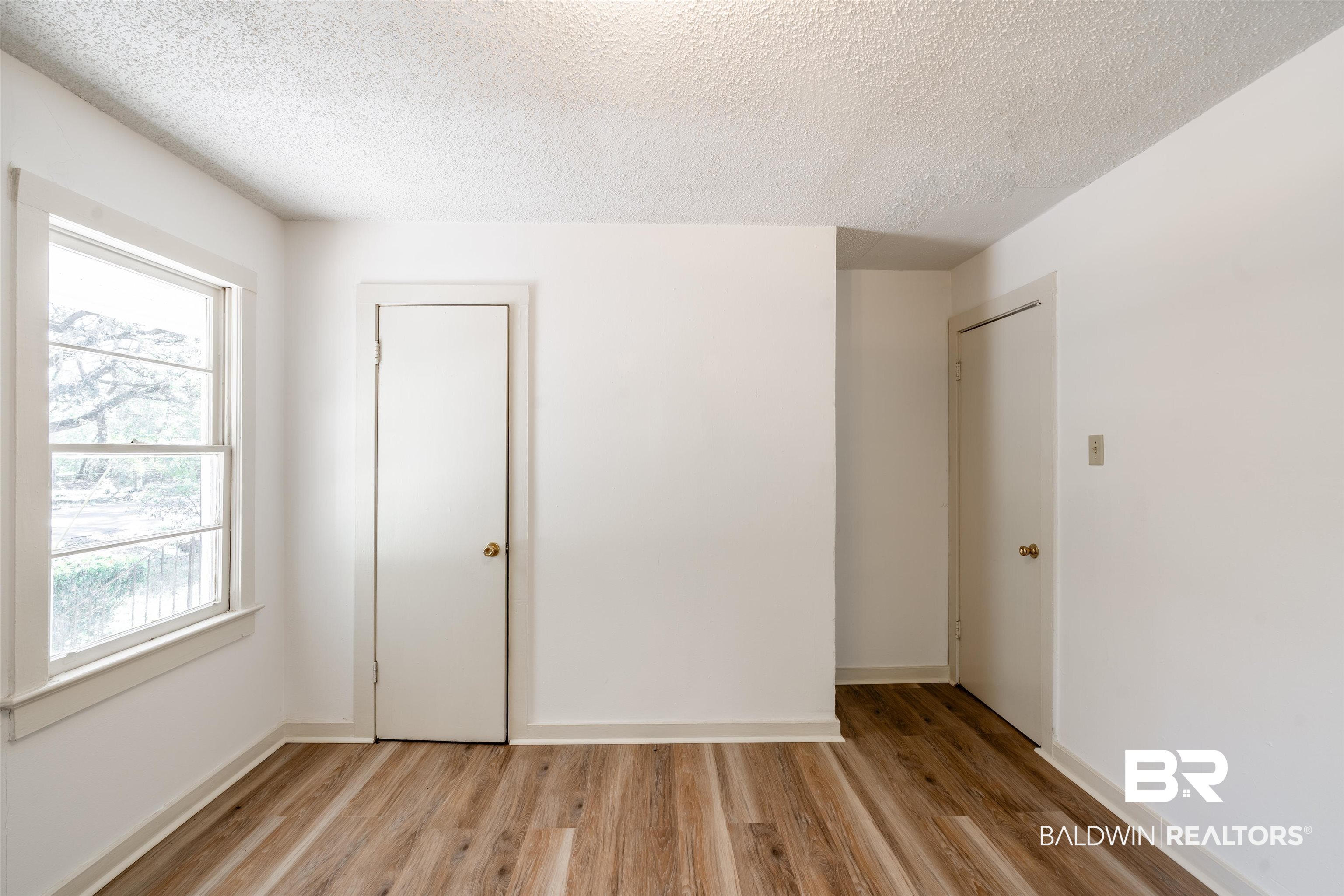 3900 Brookmont Drive Mobile, AL 36605 - Photo 14 of 19 Unfurnished room with a textured ceiling, light hardwood / wood-style flooring, and a wealth of natural light