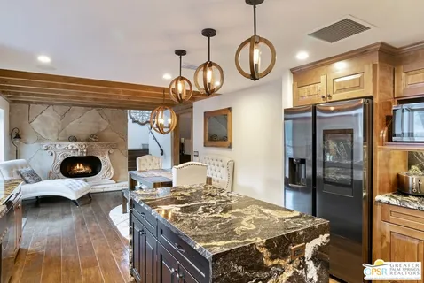 a kitchen with stainless steel appliances granite countertop a stove a sink and a refrigerator