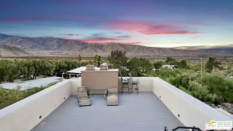 a roof deck with table and chairs