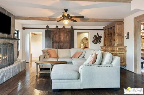 a dining room with wooden floor a chandelier a wooden table and chairs