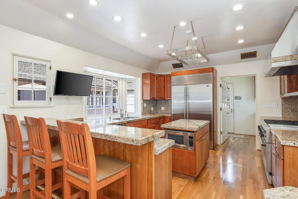 369 West Kenneth Road Glendale, CA 91202 - Photo 14 of 36 a kitchen with stainless steel appliances granite countertop a sink refrigerator and microwave