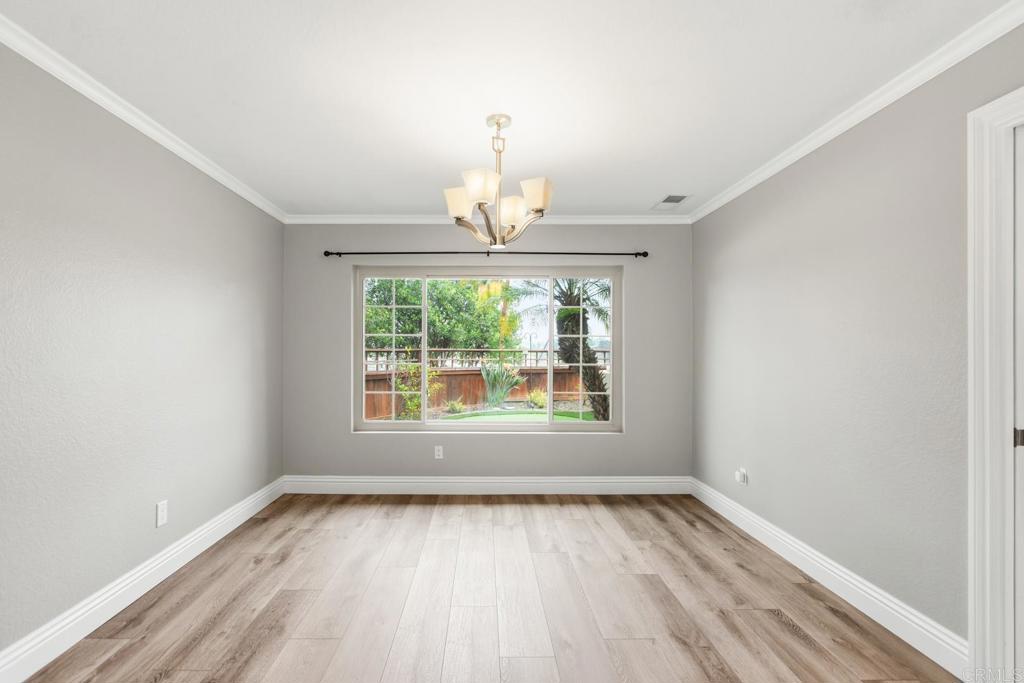 391 Via Almansa Encinitas, CA 92024 - Photo 13 of 35 an empty room with wooden floor a exposed radiator and a window