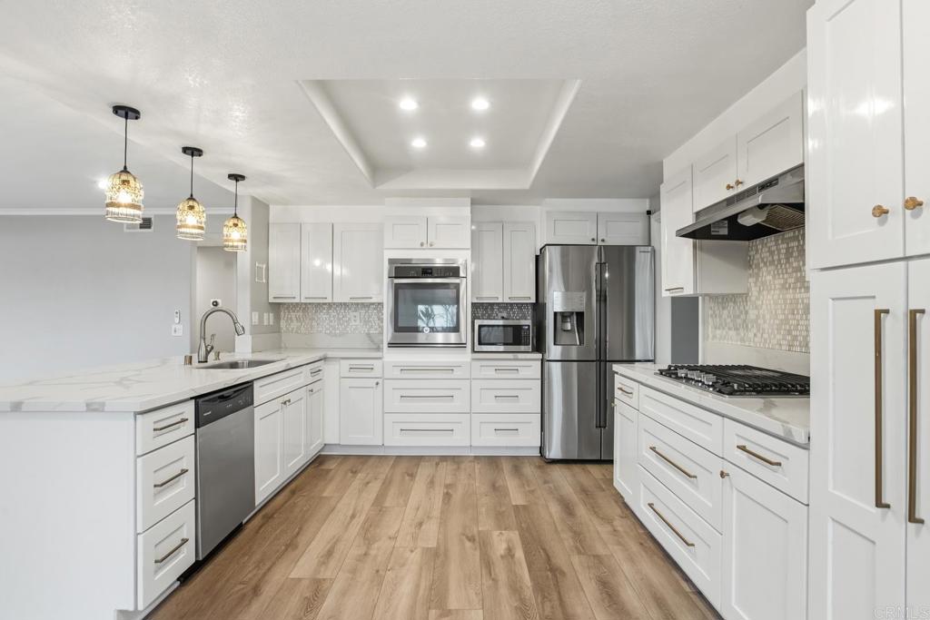 391 Via Almansa Encinitas, CA 92024 - Photo 10 of 35 a kitchen with white cabinets and stainless steel appliances