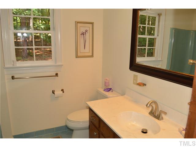 5004 Springwood Drive Raleigh, NC 27613 - Photo 19 of 22 a bathroom with a sink a toilet and mirror