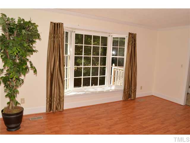 5004 Springwood Drive Raleigh, NC 27613 - Photo 6 of 22 a view of an empty room with a potted plant and a window
