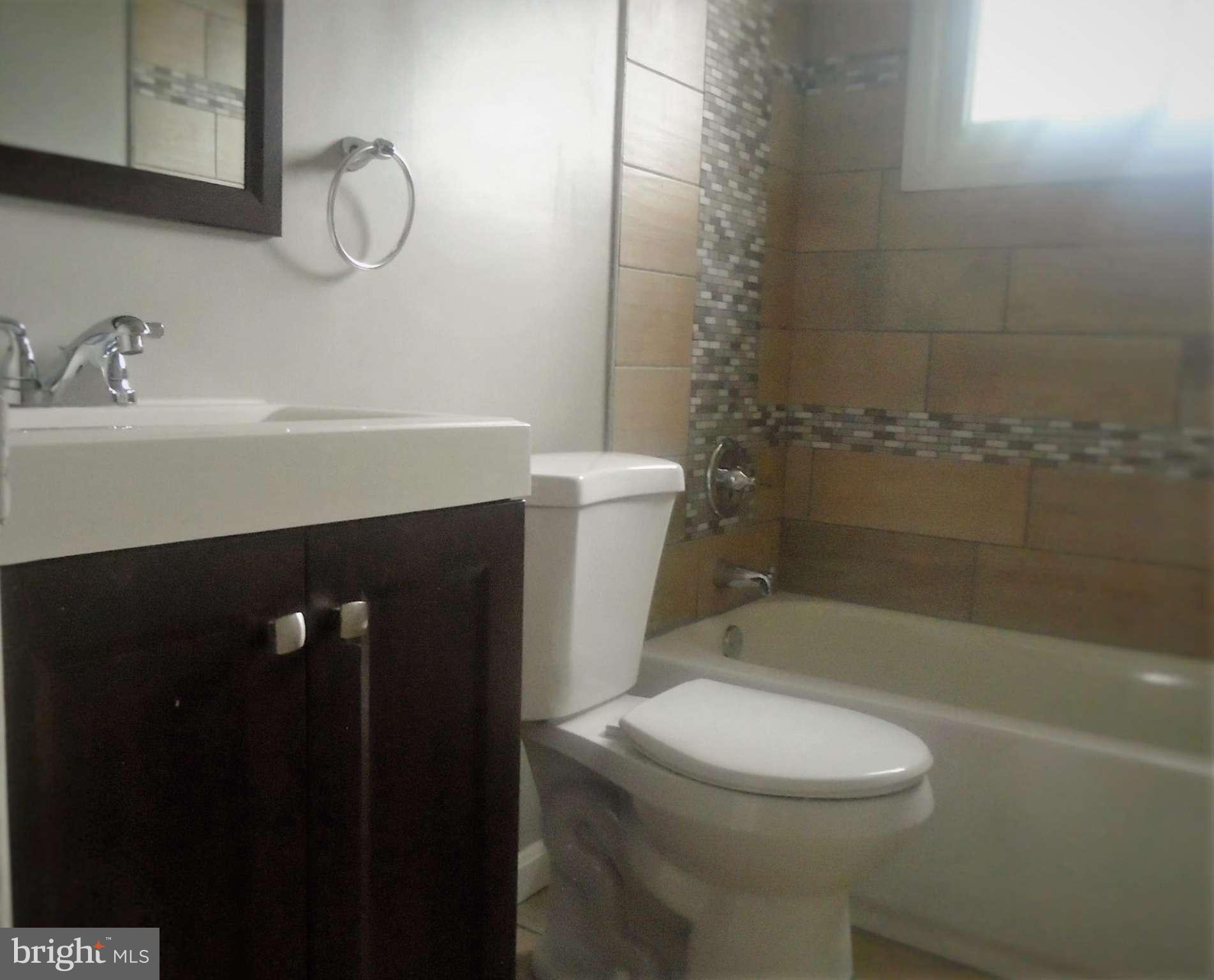 1140 Cedarcroft Road Baltimore, MD 21239 - Photo 13 of 23 a bathroom with a sink a toilet and shower