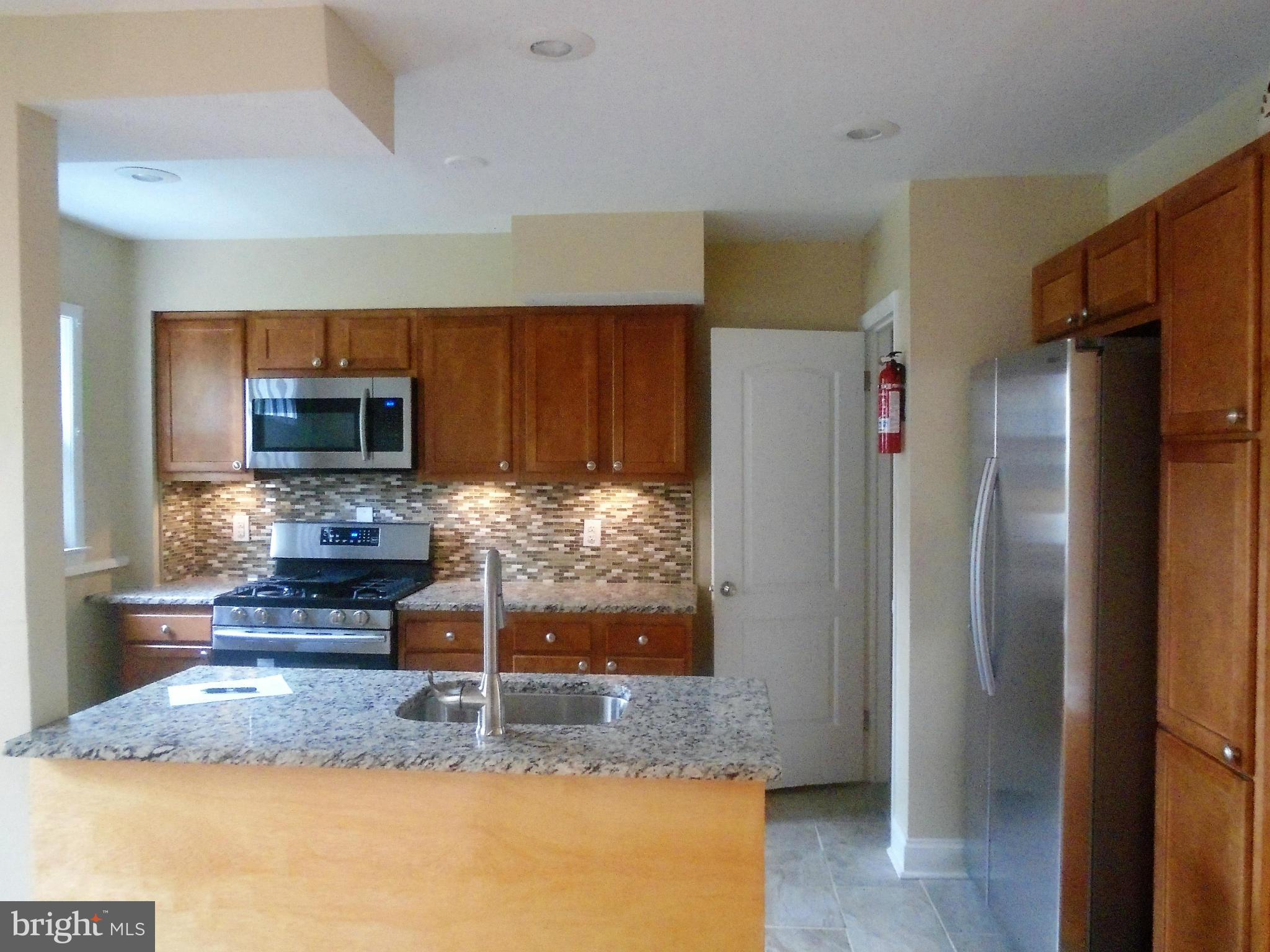 1140 Cedarcroft Road Baltimore, MD 21239 - Photo 7 of 23 a kitchen with a refrigerator and a counter top space