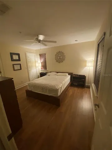 a bedroom with a bed and wooden floor