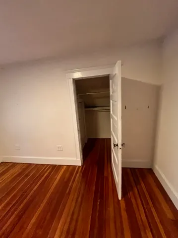 a view of staircase with lots of frames on wall and wooden floor