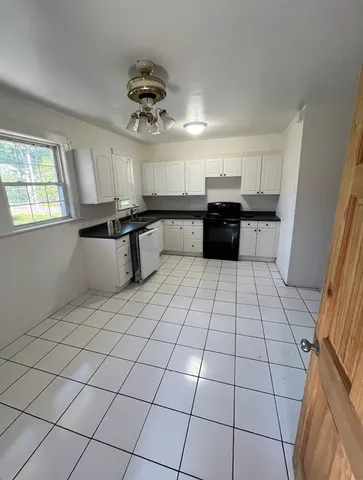 a kitchen with a sink a stove cabinets and counter space