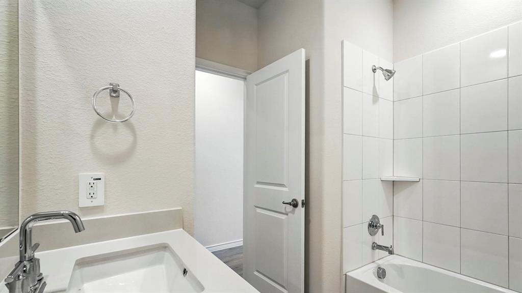 4191 Waldron Trail Forney, TX 75126 - Photo 16 of 20 Bathroom featuring a white vanity with an integrated sink, chrome faucet, and coordinating towel ring
