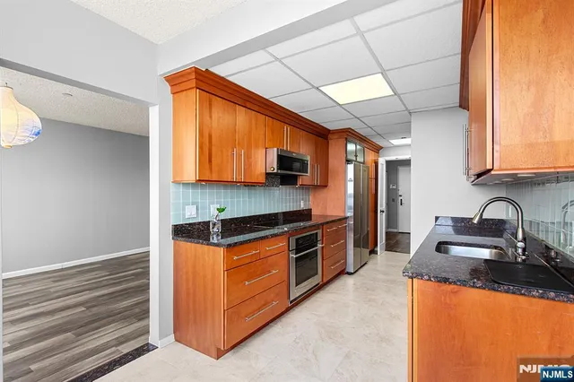 a kitchen with stainless steel appliances granite countertop a sink stove and microwave