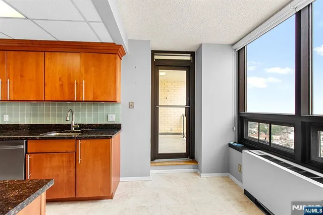 a kitchen with granite countertop sink stove and cabinets