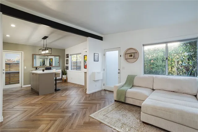 a living room with furniture and view of kitchen