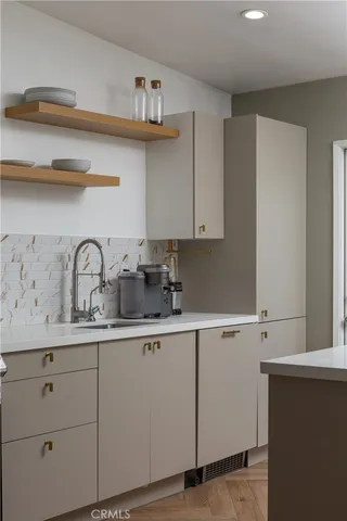 a kitchen with white cabinets a sink and dishwasher