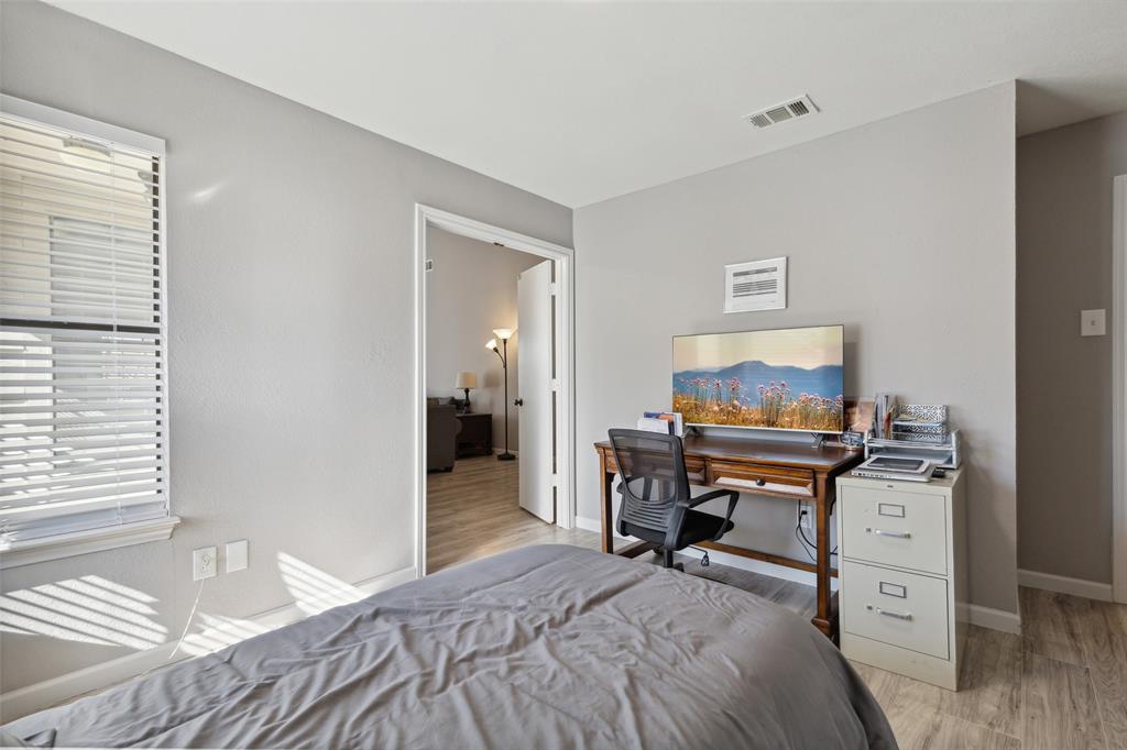 19016 Tupelo Lane Dallas, TX 75007 - Photo 11 of 28 a bedroom with a bed and a flat screen tv