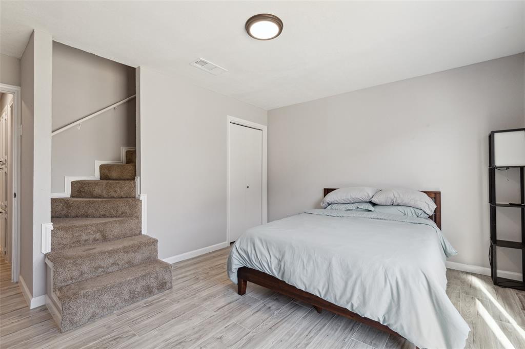 19016 Tupelo Lane Dallas, TX 75007 - Photo 19 of 28 a bedroom with a bed and white walls