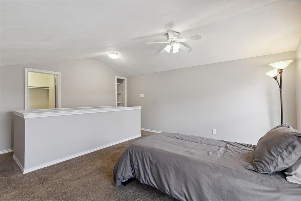 19016 Tupelo Lane Dallas, TX 75007 - Photo 21 of 28 a bedroom with a bed and a chandelier