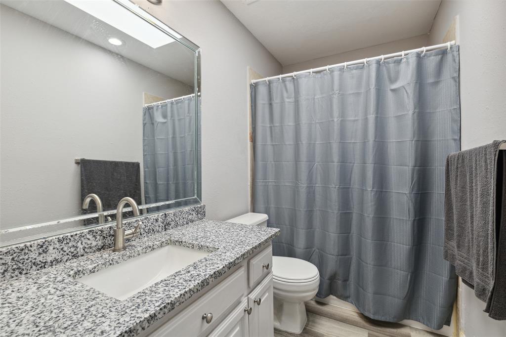 19016 Tupelo Lane Dallas, TX 75007 - Photo 22 of 28 a bathroom with a granite countertop sink and a mirror