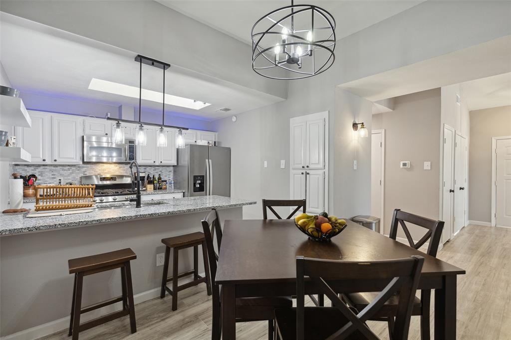 19016 Tupelo Lane Dallas, TX 75007 - Photo 6 of 28 a kitchen with stainless steel appliances granite countertop a dining table chairs and white cabinets