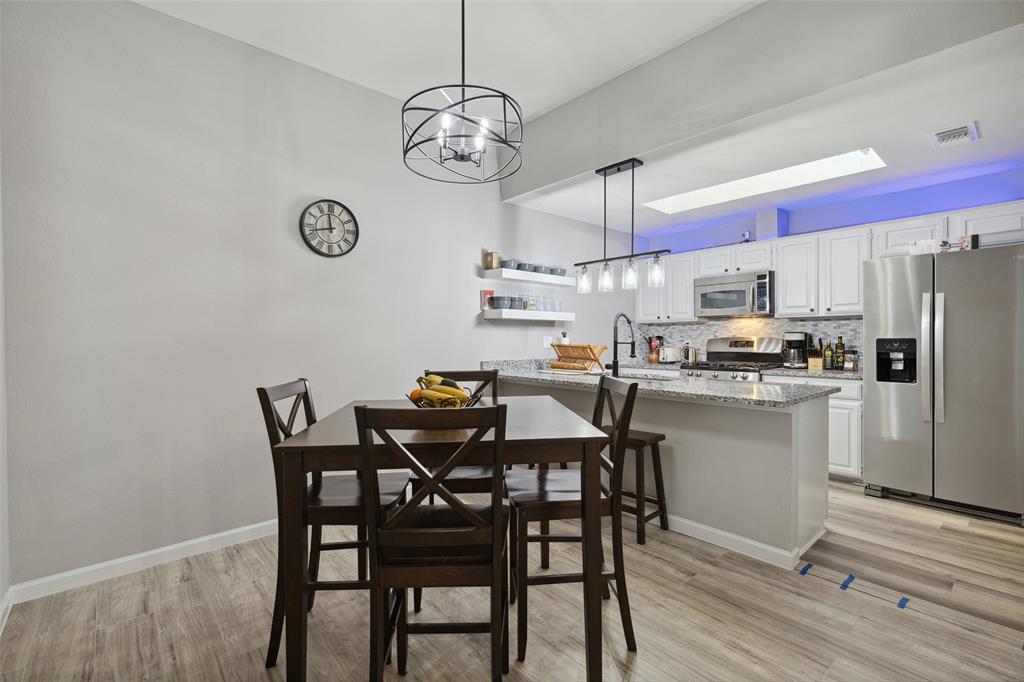 19016 Tupelo Lane Dallas, TX 75007 - Photo 7 of 28 a kitchen with a dining table chairs and refrigerator