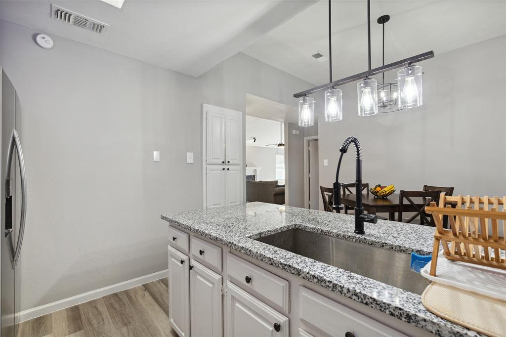 19016 Tupelo Lane Dallas, TX 75007 - Photo 9 of 28 a kitchen with a sink and a refrigerator