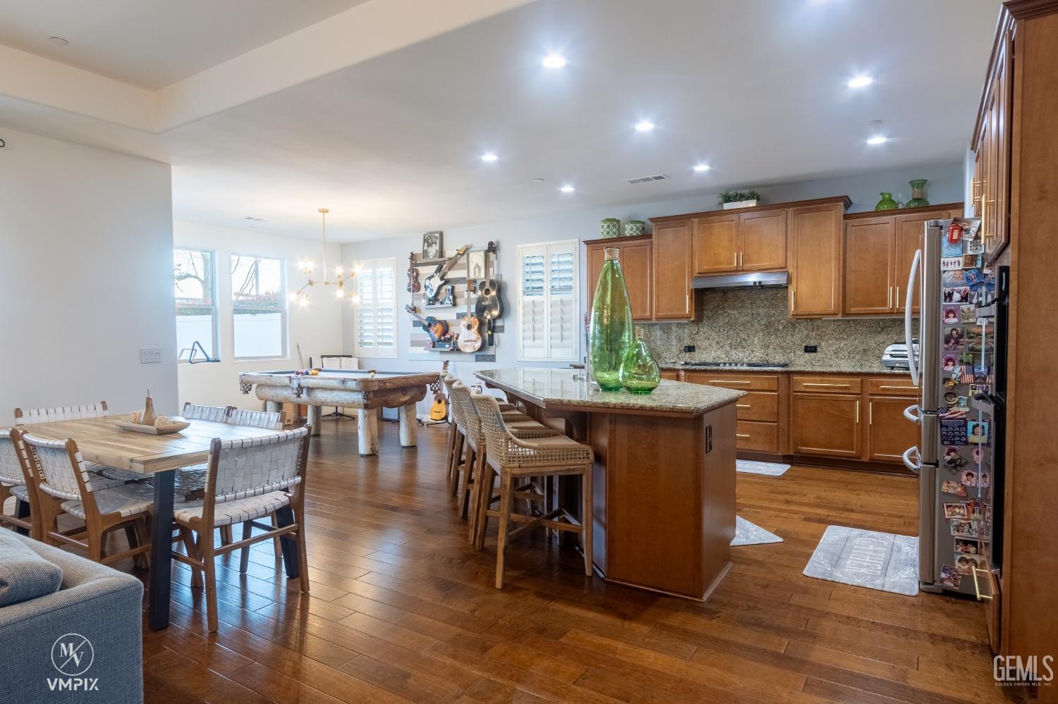 Undisclosed Address Bakersfield, CA 93311 - Photo 11 of 55 a kitchen with a dining table chairs and wooden floor
