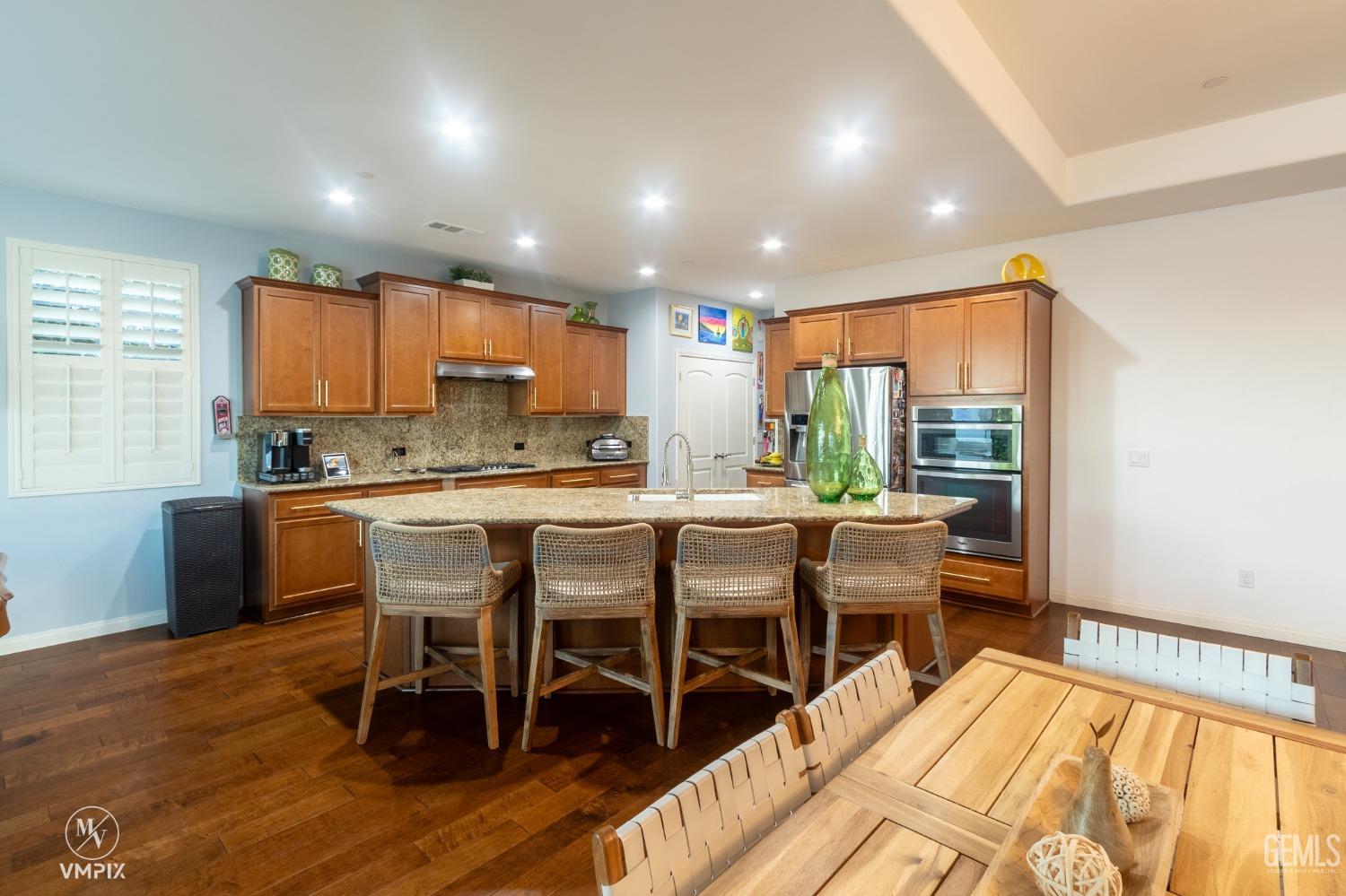 Undisclosed Address Bakersfield, CA 93311 - Photo 15 of 55 a dining room with stainless steel appliances kitchen island granite countertop a dining table chairs and granite counter tops