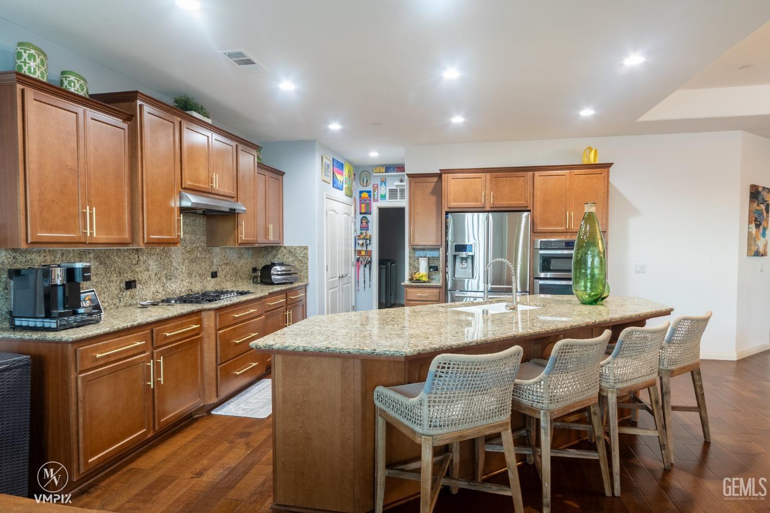 Undisclosed Address Bakersfield, CA 93311 - Photo 16 of 55 a kitchen with granite countertop sink table and chairs