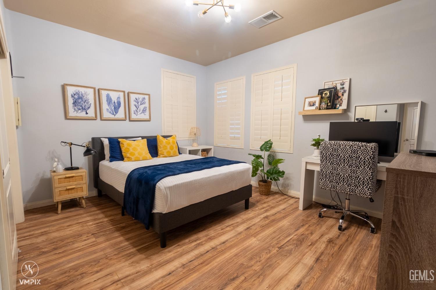 Undisclosed Address Bakersfield, CA 93311 - Photo 25 of 55 a spacious bedroom with a bed and wooden floor