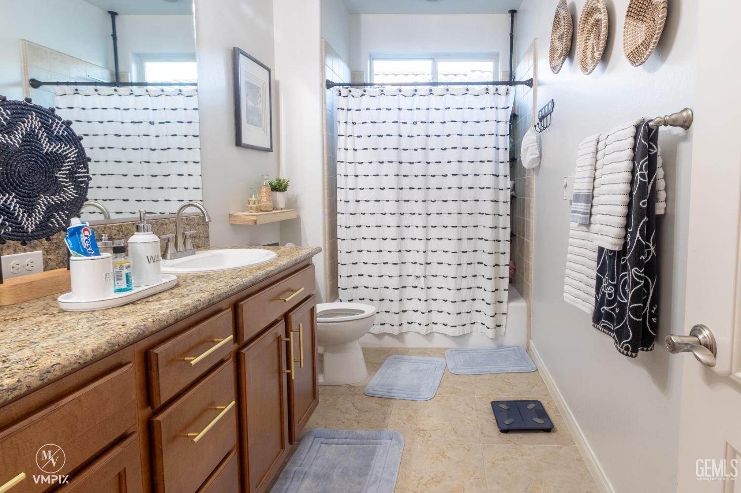 Undisclosed Address Bakersfield, CA 93311 - Photo 27 of 55 a bathroom with a granite countertop sink a toilet and shower