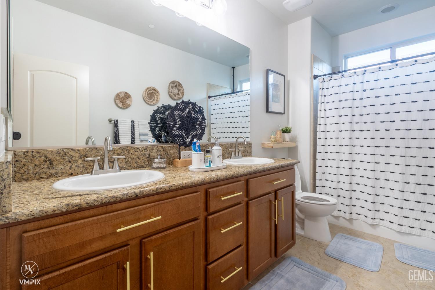 Undisclosed Address Bakersfield, CA 93311 - Photo 28 of 55 a bathroom with a granite countertop toilet sink and mirror