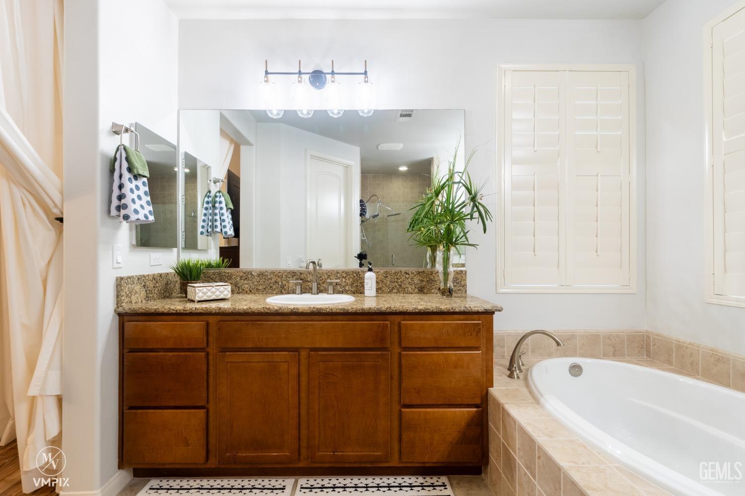 Undisclosed Address Bakersfield, CA 93311 - Photo 35 of 55 a bathroom with a tub sink and mirror