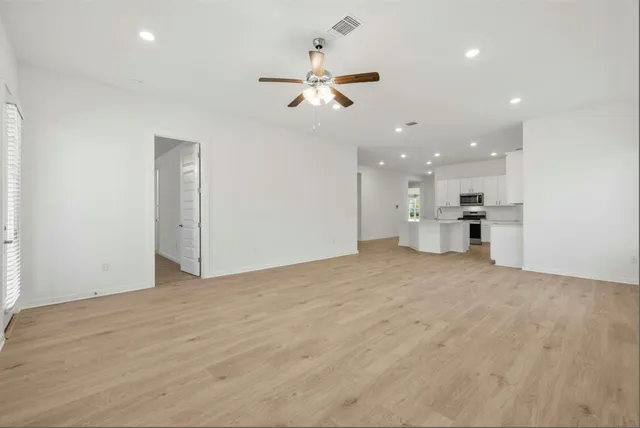 a view of an empty room and kitchen view