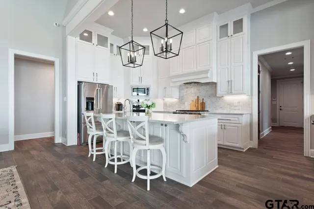 a kitchen with stainless steel appliances kitchen island granite countertop a table and chairs in it