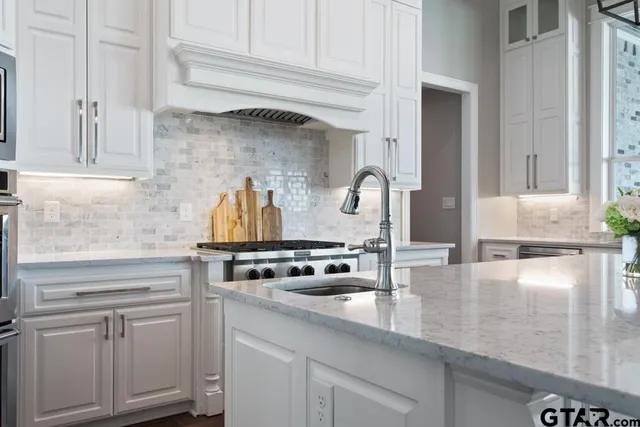 a kitchen with white cabinets and a stove