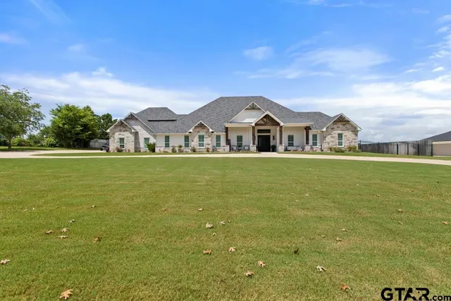 a view of a house with a big yard and large trees