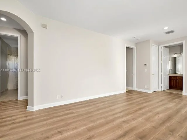 a spacious bedroom with a bed a couch and a large window